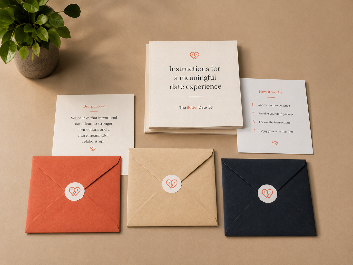 Overhead photo of the package contents: an instructions booklet, a 'how it works' card and three sealed date-stage envelopes on a tabletop, with a small plant nearby